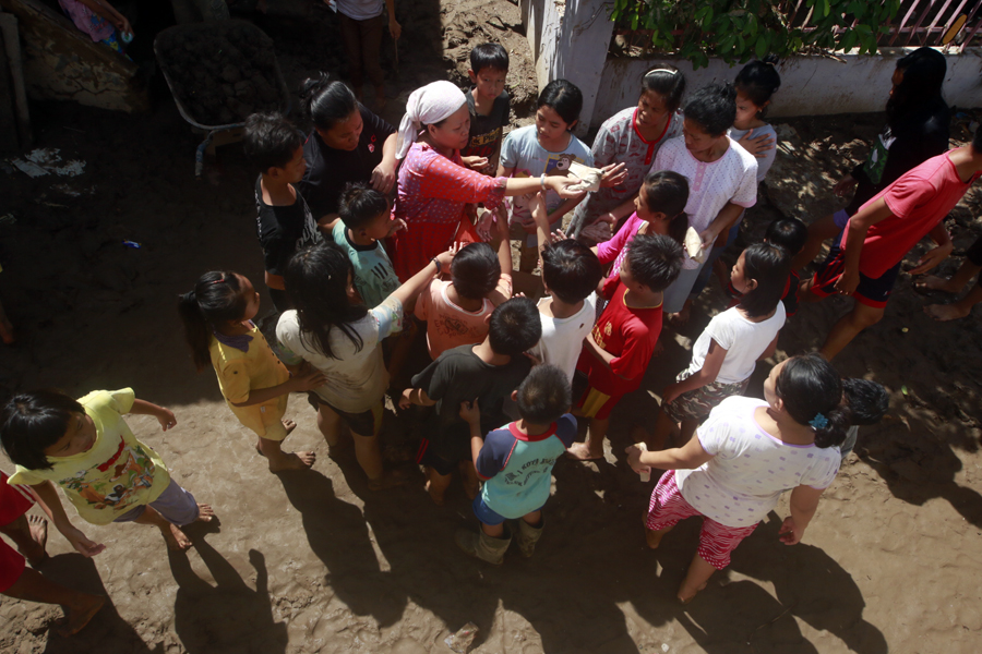 Para korban banjir berebut bantuan nasi bungkus dan popok bayi yang diberikan Yayasan Sedekah Seribu Sehari di Jalan Ikan Sebelah, Pesawahan, Telukbetung Selatan, Rabu (22/02). (Foto: Lampungnews.com/El Shinta)
