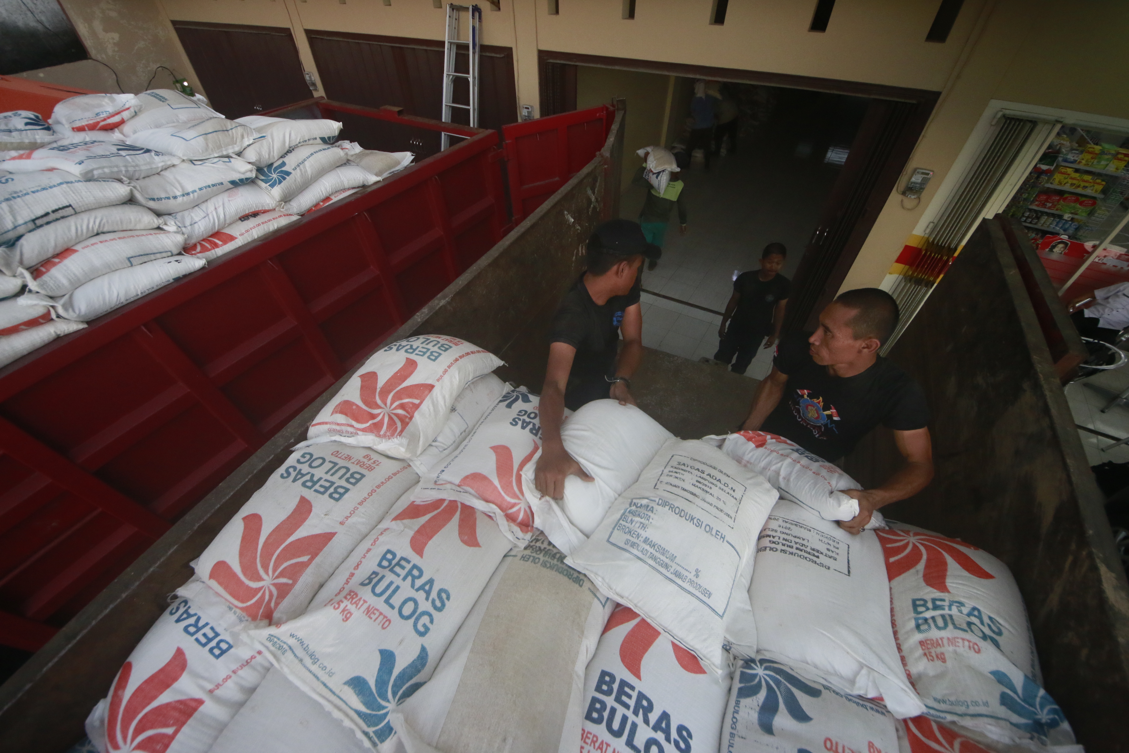 Petugas BPBD Kota Bandar Lampung menurunkan 1.041 karung beras dari mobil truk di posko terpadu bencana, di Jalan KH. Hasyim Asharai, Rabu (22/2). Rencananya bantuan beras ini akan dibagikan kepada korban banjir di Telukbetung. (Lampungnews/El Shinta)
