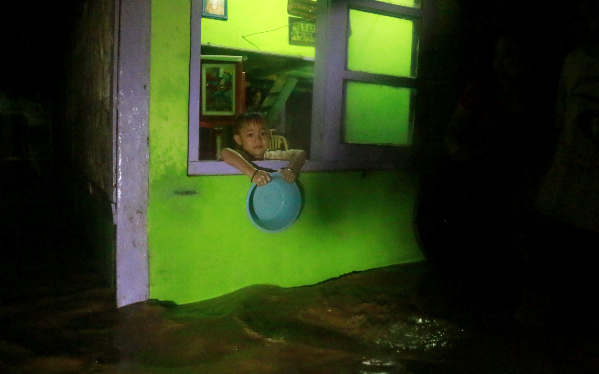 Seorang anak melihat banjir yang merendam ratusan rumah di Jalan Ikan Sebelah, Telukbetung Selatan, Senin malam. (Lampungnews/El Shinta)