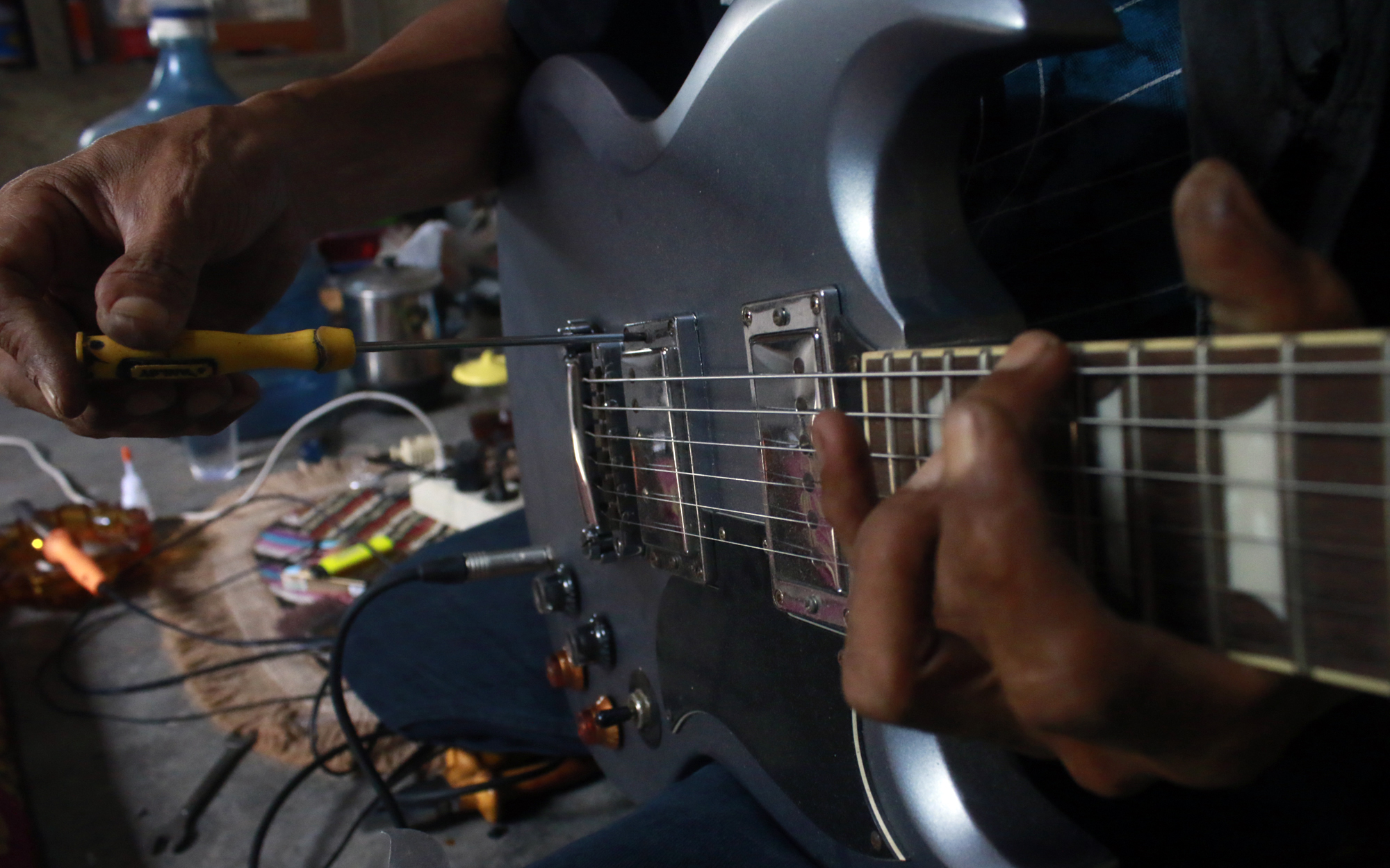 Proses penyetelan suara pada senar gitar agar suara petikan yang dihasilkan bersih. (Lampungnews/El Shinta)