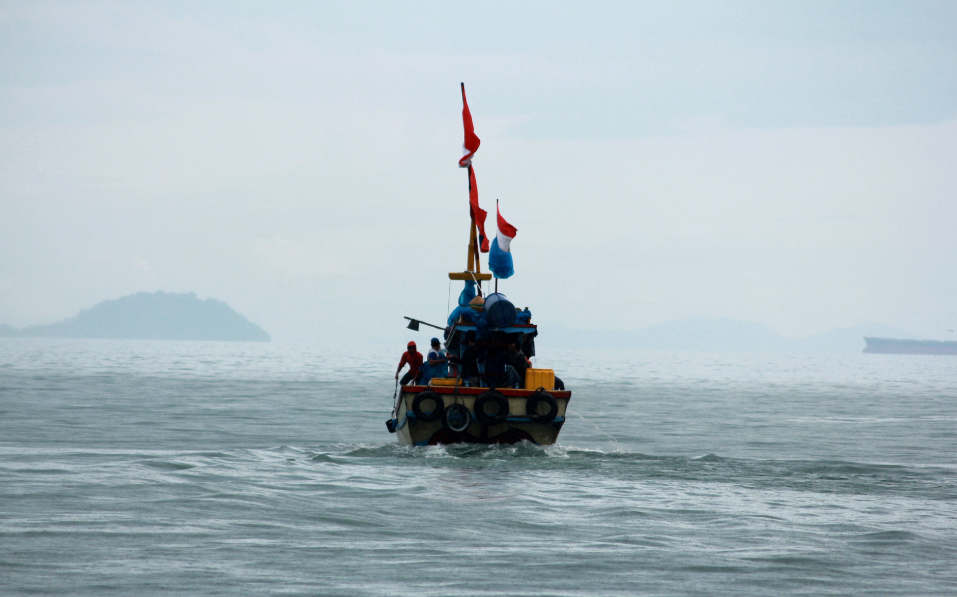 Dalam kondisi hujan, sebuah kapal nelayan tetap berlayar untuk mencari ikan di perairan Teluk Lampung. (Lampungnews/El Shinta).