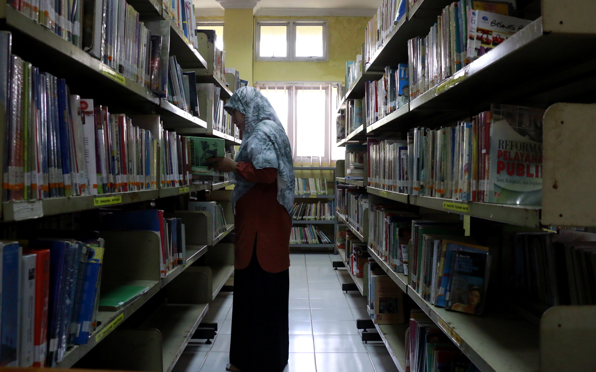 Seorang pemustaka tengah memilih buku di Dinas Perpustakaan dan Arsip Lampung. (Lampungnews/El Shinta)