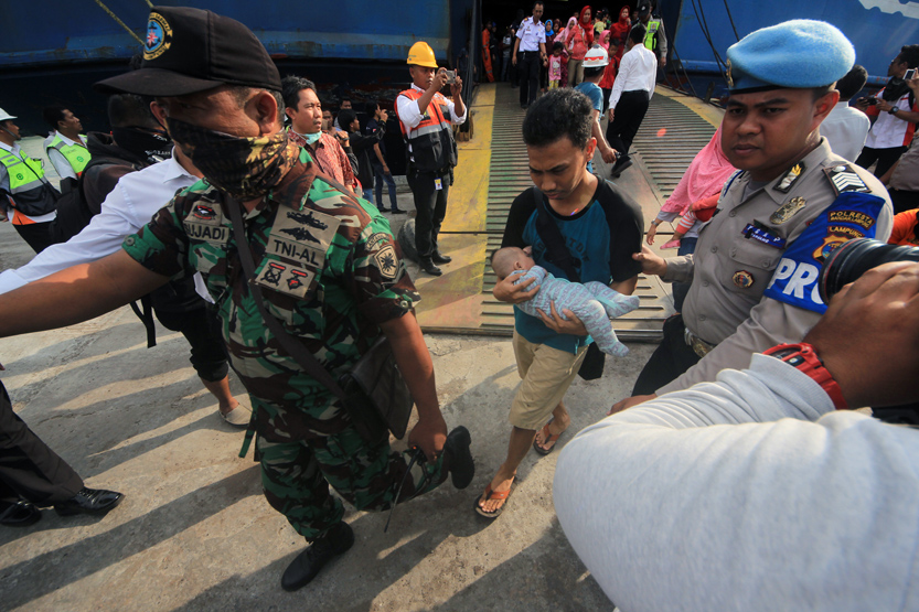 Salah satu penumpang Kapal RORO KMP Mutiara Persada III yang terbakar, menggendong bayinya menuju mobil ambulans yang disediakan untuk para korban. (Lampungnews/El Shinta)