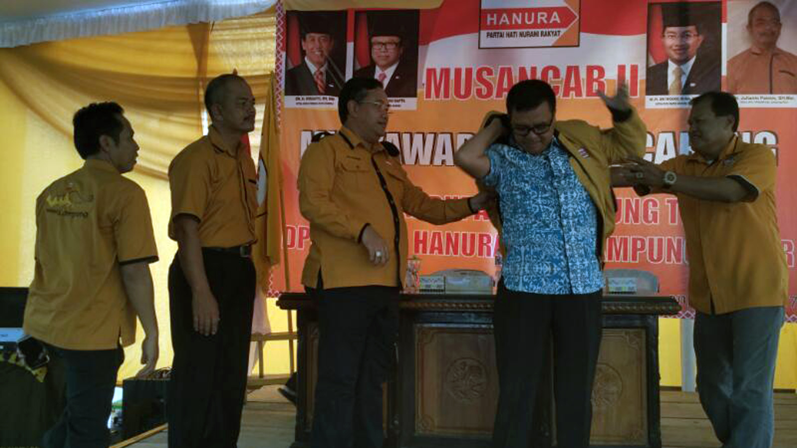 Ketua DPD Hanura Lampung Sri Widodo memakaikan jaket kepada Taufik Hidayat, salah satu tokoh masyarakat setempat yang bergabung ke Partai Hanura, pada acara Musancab bersama PAC Hanura se Lamtim, Minggu (16/4). (Ist)
