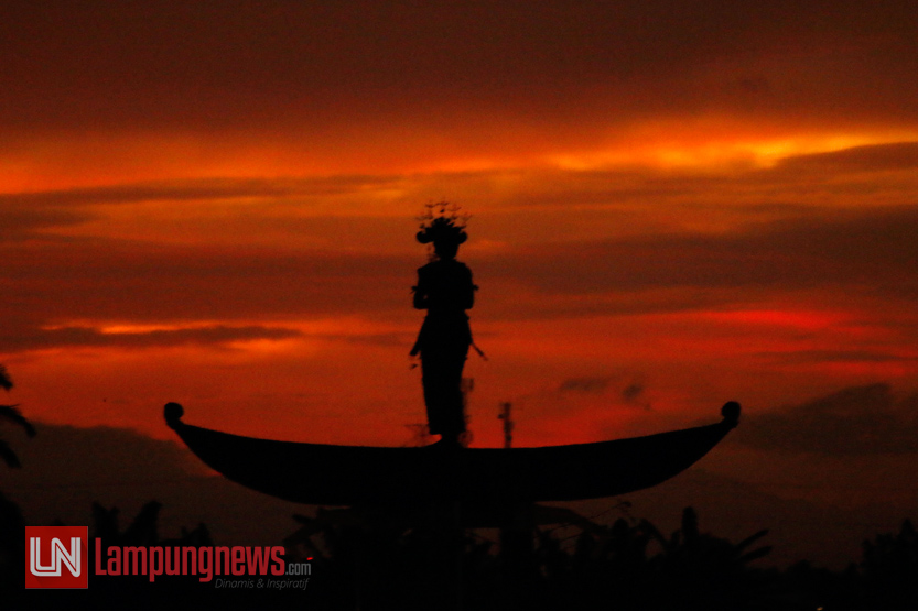 Senja memburat menampilkan siluet nan eksotis patung Muli Lampung. (Lampungnews/El Shinta)
