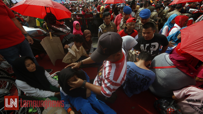 Sejumlah warga yang pingsan ditolong seadanya oleh warga lainnya. (Lampungnews/El Shinta)