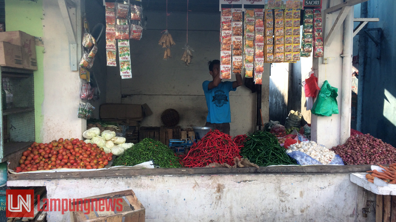 Seorang pedangan merapikan sembako yang dijualnya di Pasar Kangkung, Selasa (16/5). Jelang Ramadan, harga sembako mulai merambat naik. Tercatat, bawang putih mengalami kenaikan paling tinggi. (Lampungnews/Dinda)
