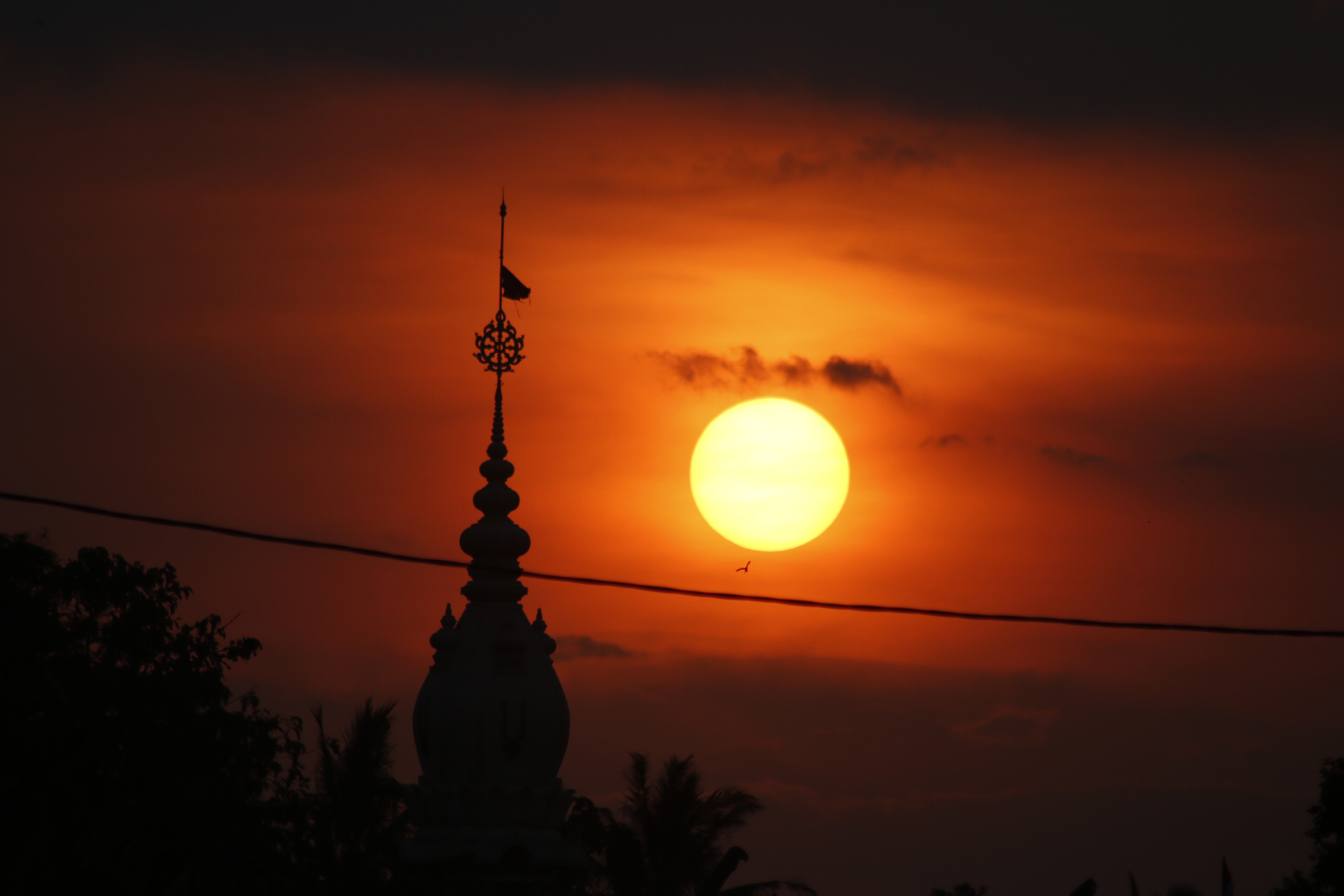 Sunset dengan siluet puncak menara bangunan Sri Sri Radha Giridhari Asram atau asrama tempat belajar Weda di Desa Jatiagung, Jatimulyo, Lampung Selatan, Minggu (21/5). Pemandangan matahari terbenam dengan langit warna menjingga belakangan kerap menghiasi langit di Lampung.