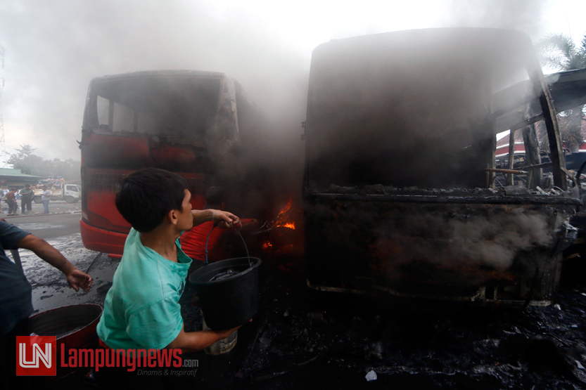 Beberapa sopir bus dibantu warga sekitar memadamkan api dengan menyiramkan air yang ada di kamar mandi Pool Damri, Rajabasa, Rabu (3/5). (Lampungnews/El Shinta)