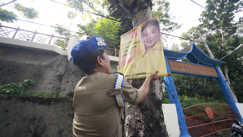 Personil Bapol PP Bandarlampung menertibkan banner yang terpasang di pohon di Jalan Basuki Rahmat, Senin (10/7). (Lampungnews/El Shinta)