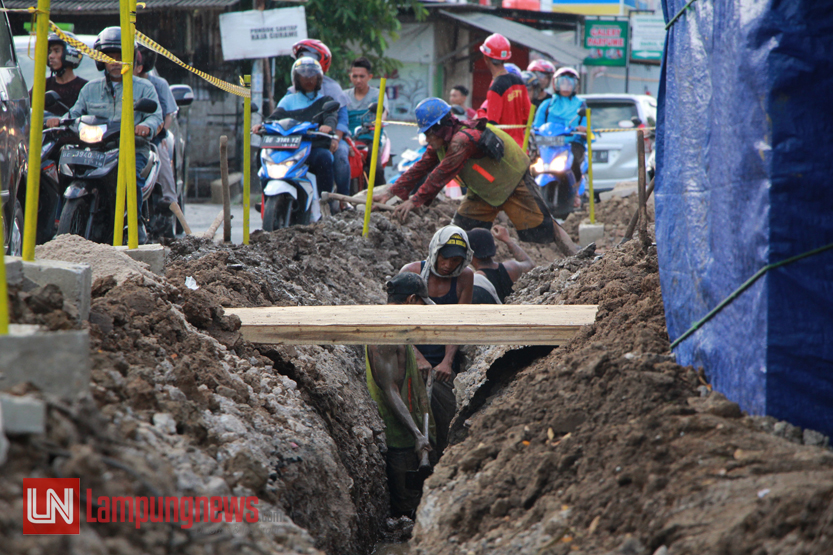 Sejumlah pekerja mengeruk saluran pemasangan pipa gas bumi di Jalan Panglima Polim, Selasa (11/7). Program dari Kementerian ESDM ini direncanakan akan menyentuh 10 ribu KK di Bandarlampung. (Lampungnews/El Shinta)