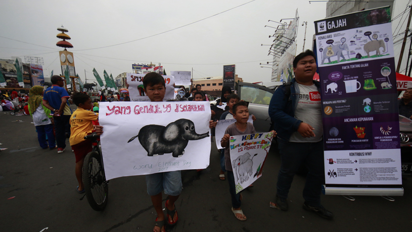 Sejumlah anak-anak membawa poster bergambar gajah dan menyerukan selamatkan gajah dengan mengelilingi area Car Free Day di Tugu Adipura, Minggu (13/8). (Lampungnews/El Shinta)