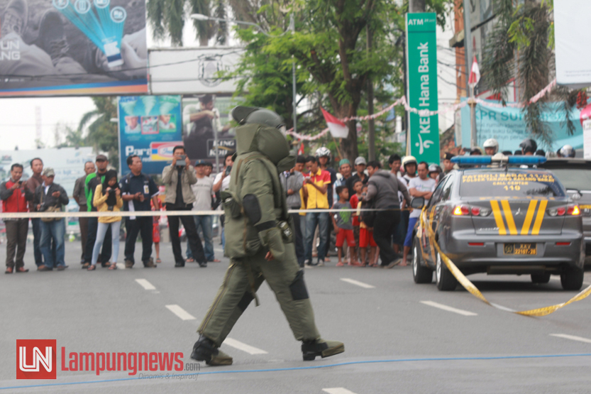 Seorang anggota Detasemen Jibom Gegana Brimob Polda Lampung yang berpakaian khusus menuju pelataran Masjid Jami Al Yaqin untuk mengambil tas dan plastik yang diduga bom, Rabu (6/9). (Lampungnews/El Shinta)