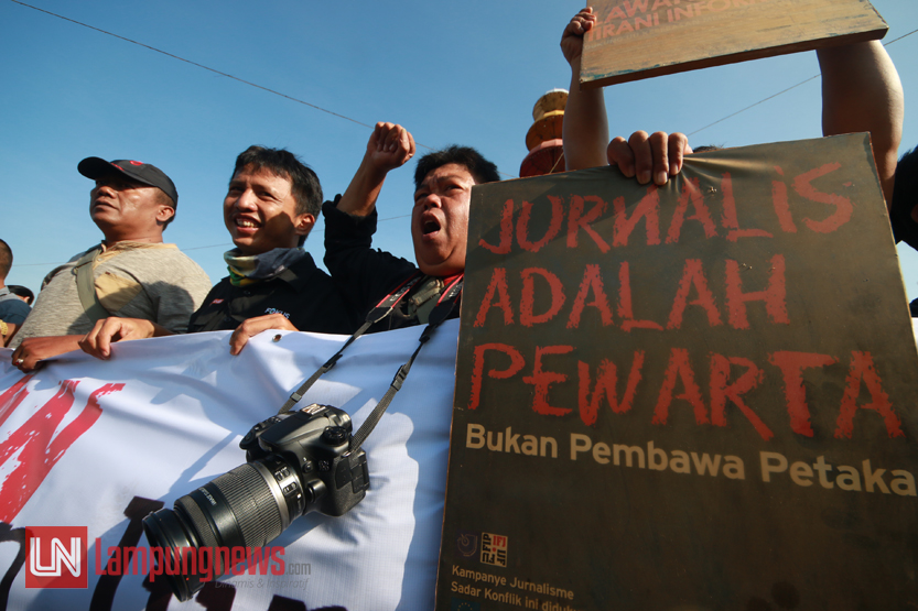 Puluhan jurnalis dari berbagai organisasi profesi seperti PWI Lampung, AJI Bandarlampung, IJTI Pengda Lampung, dan PFI Lampung menggelar aksi damai dan mengecam keras atas tindakan kekerasan terhadap jurnalis di Tugu Adipura, Jumat (13/10). Aksi ini sebagai bentuk solidaritas terhadap sejumlah wartawan media elektronik dan cetak yang menjadi korban kekerasan saat meliput pembubaran paksa aksi demo di Alun-laun Purwokerto, Banyumas, Senin (9/10) lalu. (Lampungnews/El Shinta)