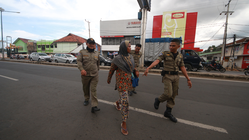 Personel Bapol PP Kota Bandarlampung menangkap pengemis yang beraksi di Jalan ZA Pagar Alam, Selasa (14/11). (Lampungnews.com/El Shinta)